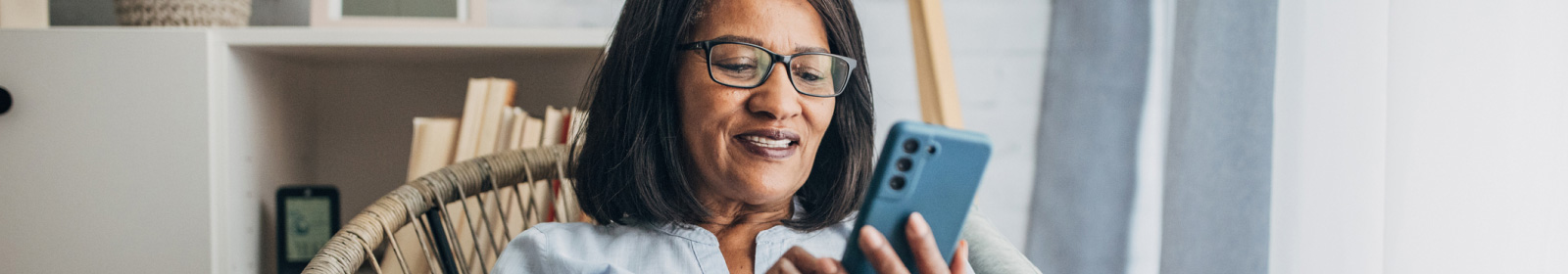 middle-aged woman wearing glasses viewing her mobile phone