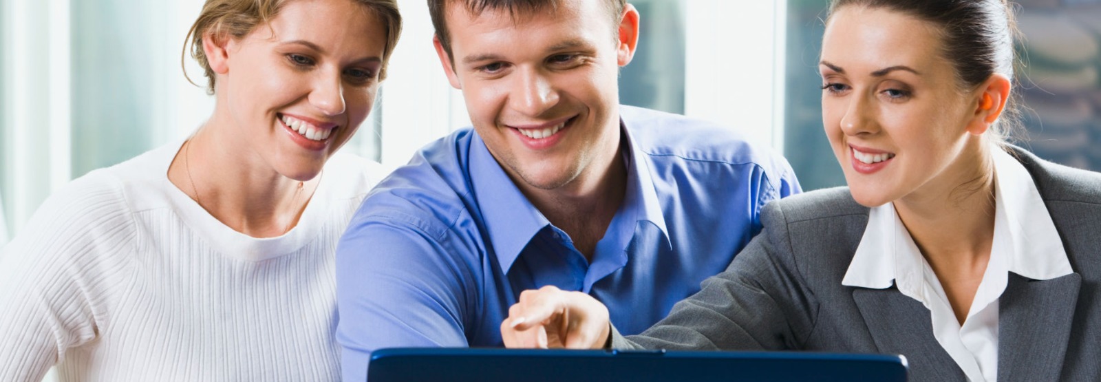 Three people looking at a laptop computer