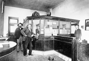 Historic bank interior layout with patrons standing at counter