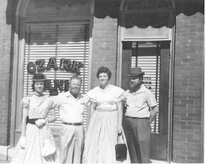 Men and women standing outside of original Ozark Bank location